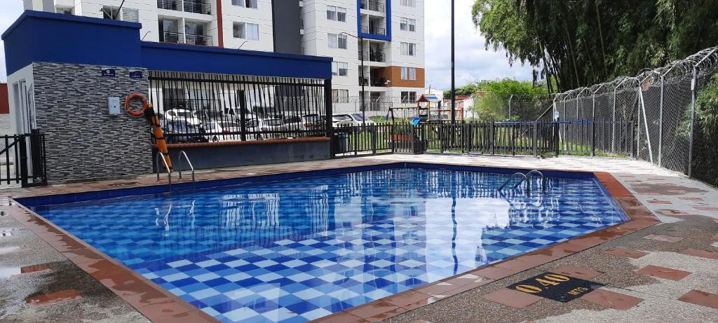 una piscina con azulejos azules en el suelo en comodo Apartamento alojamiento Pereira Gamma, en Pereira