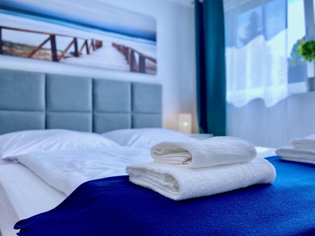 uma pilha de toalhas sentadas em cima de uma cama em InvestRooms em Gdansk