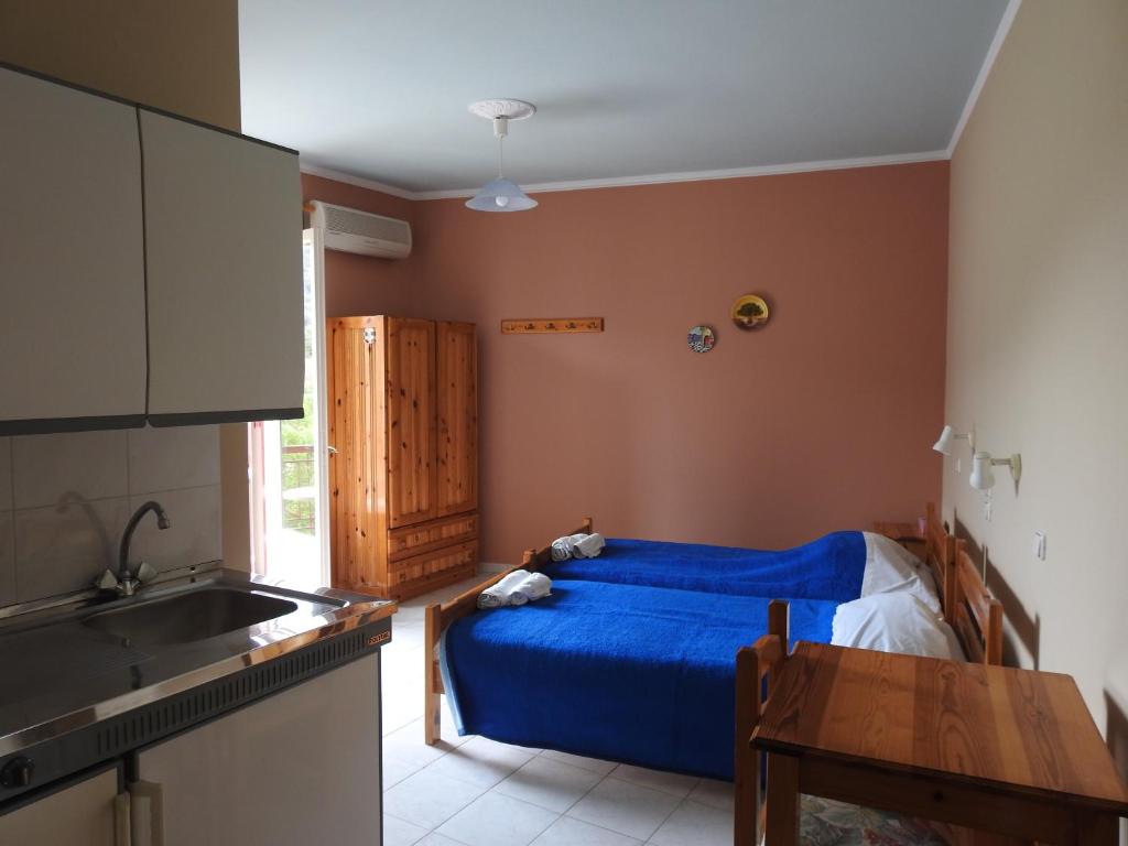 a kitchen with a bed and a sink in a room at ChiosRoomsMaria in Kalamoti