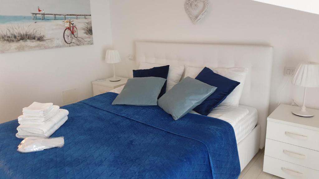 um quarto com uma cama azul e branca com almofadas azuis em B&B El Dorado em Lido di Pomposa