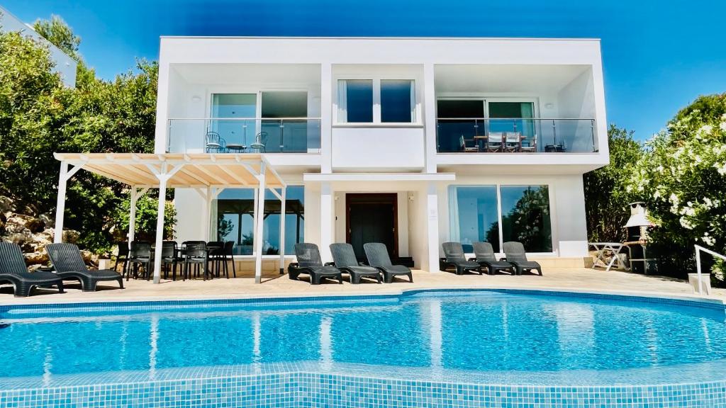 uma casa com piscina ao lado de uma villa em Villas Tin Coves Noves em Punta Grossa