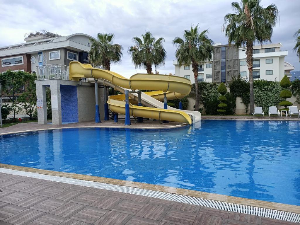 eine Rutsche mitten im Pool in der Unterkunft 2-Room Accommodation in a Luxury Resort in Alanya