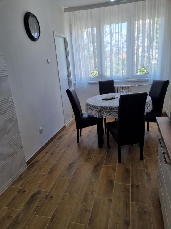 een eetkamer met een tafel en stoelen en een klok bij Stan na dan Ilvento in Vršac