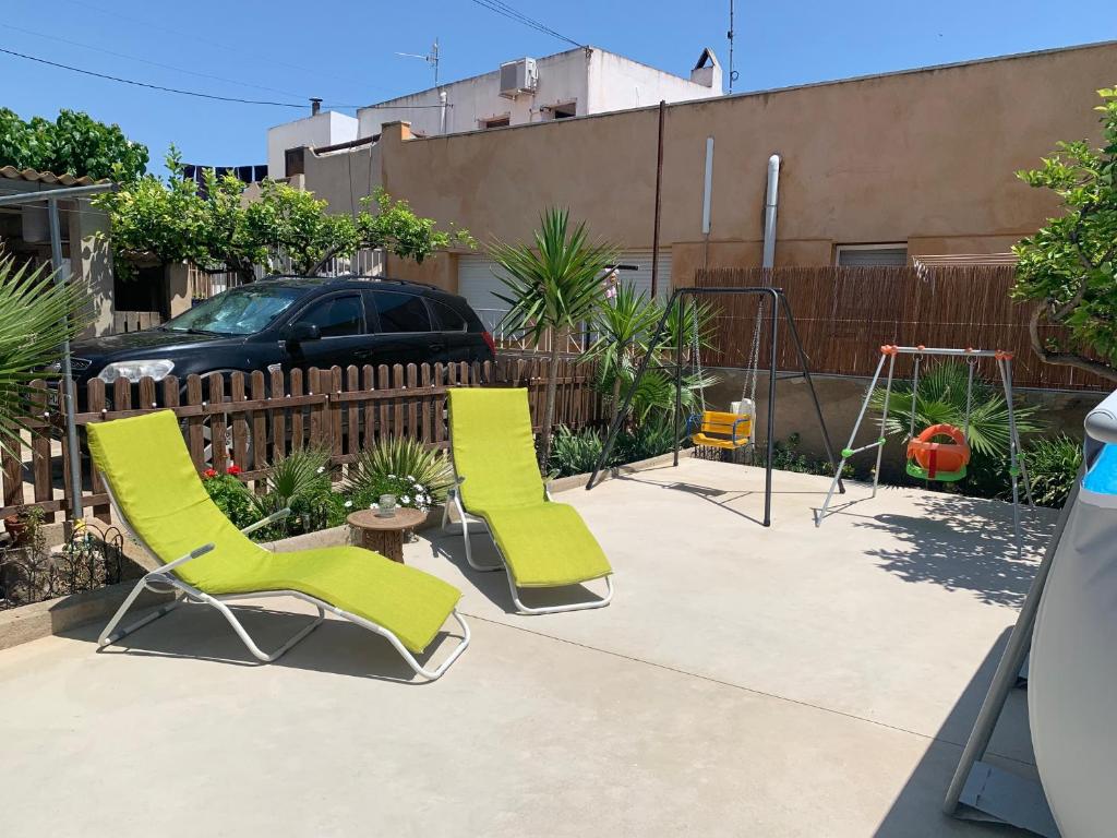 two chairs and a swing on a patio at Can Marcela in Deltebre