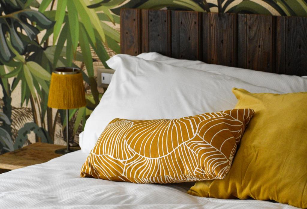 a bed with yellow and white pillows on it at Bed and Breakfast Le Giale in Castelnuovo del Garda