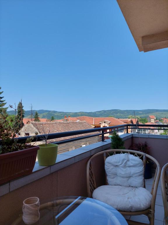 Un balcón con una silla, una mesa y vistas. en A2, en Veliko Gradiste