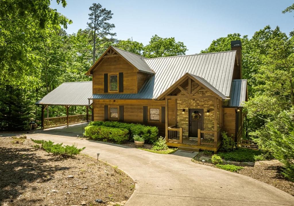 a log home with a metal roof and a driveway at Spacious cabin with resort amenities - dog friendly, hot tub, & fireplace - Bear Paw Ridge in Ellijay