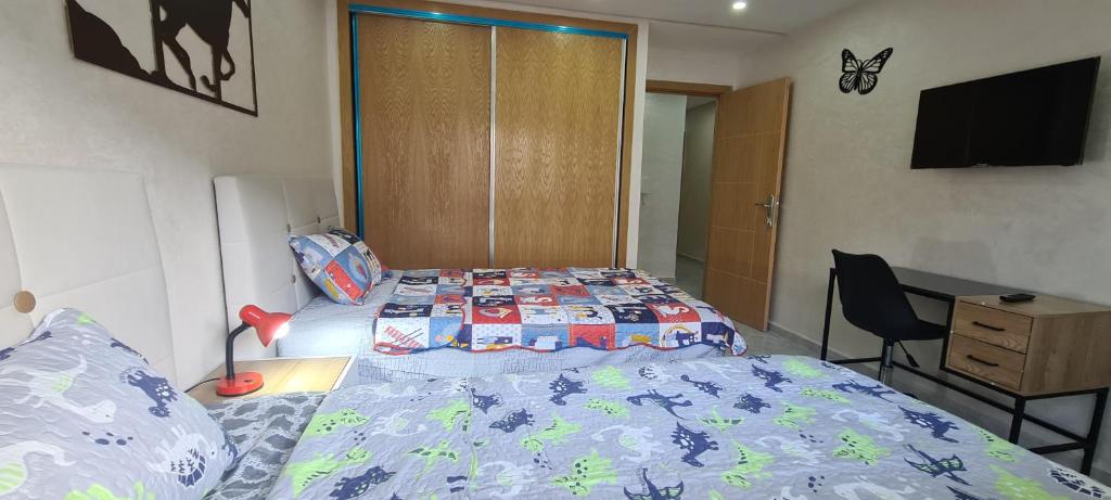 een slaapkamer met een bed en een dressoir en een bed sidx sidx bij KechAppart KENITRA in Kenitra