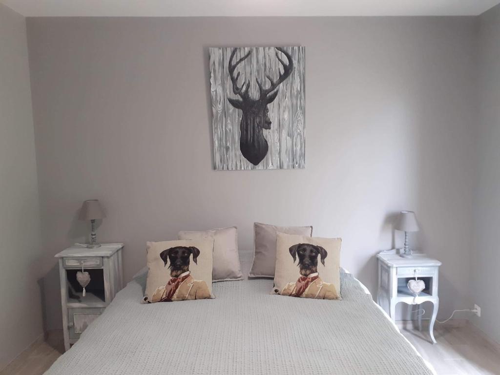 a bedroom with a bed with a deer picture on the wall at La Petite Salamandre in Chitenay