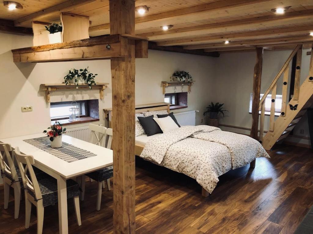 um quarto com uma cama e uma mesa e uma cama e uma mesa e cadeiras em Selská chalupa Anetka em Horšovský Týn