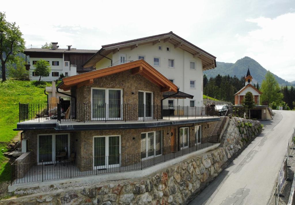 dom na kamiennej ścianie obok drogi w obiekcie Resort Hanni Deisenberger w mieście Fieberbrunn