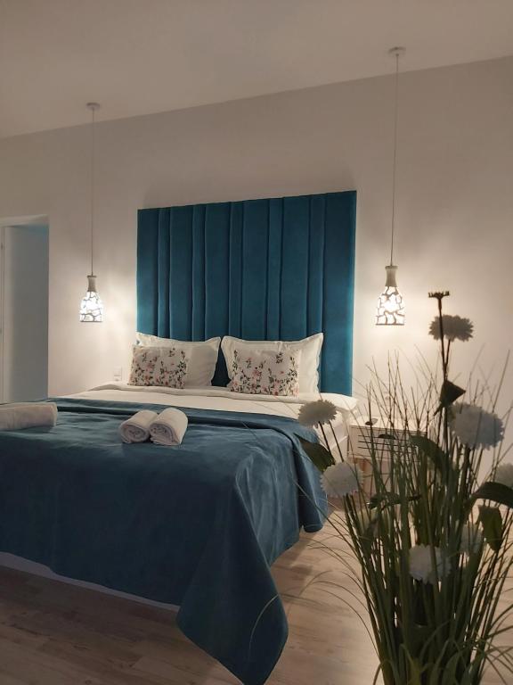 a bedroom with a large bed with a blue headboard at Accent House in Deva