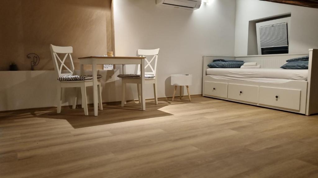 1 dormitorio con 1 cama, mesa y sillas en Apartments Lara 2, en Piran