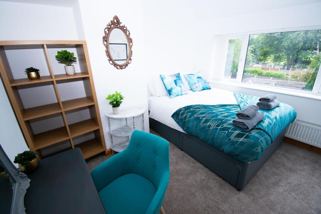 a bedroom with a bed and a chair and a mirror at Ideal Lodgings in Bury - Redvales in Bury