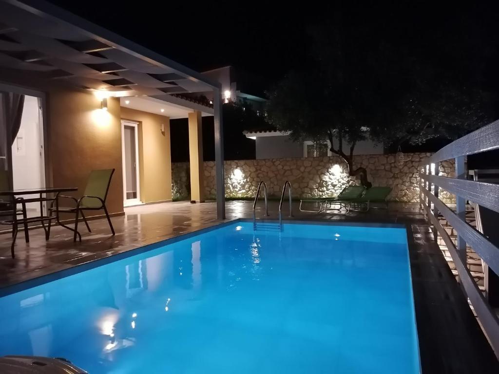 una piscina en una villa por la noche en DREAMCATCHER, en Vlachata