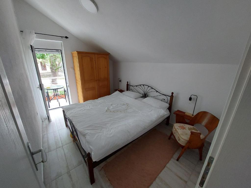 a small bedroom with a bed and a window at Apartment Nature in Sutomore