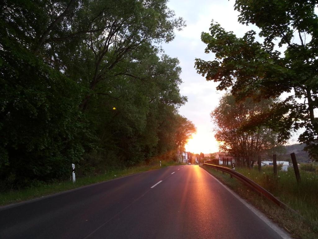 an empty road with the sun setting in the distance at Haus Saskia in Wutha-Farnroda