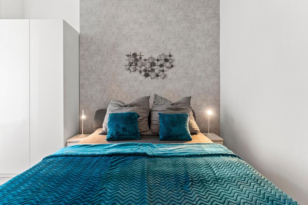 1 dormitorio con 1 cama con sábanas y almohadas azules en GreatStay - Mierendorfstr 11 Hinterhaus, en Berlín