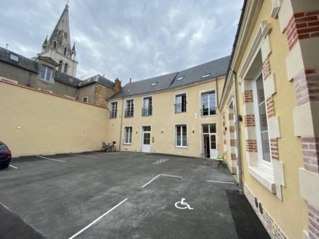 a parking lot in the middle of a building at École 102 in La Flèche