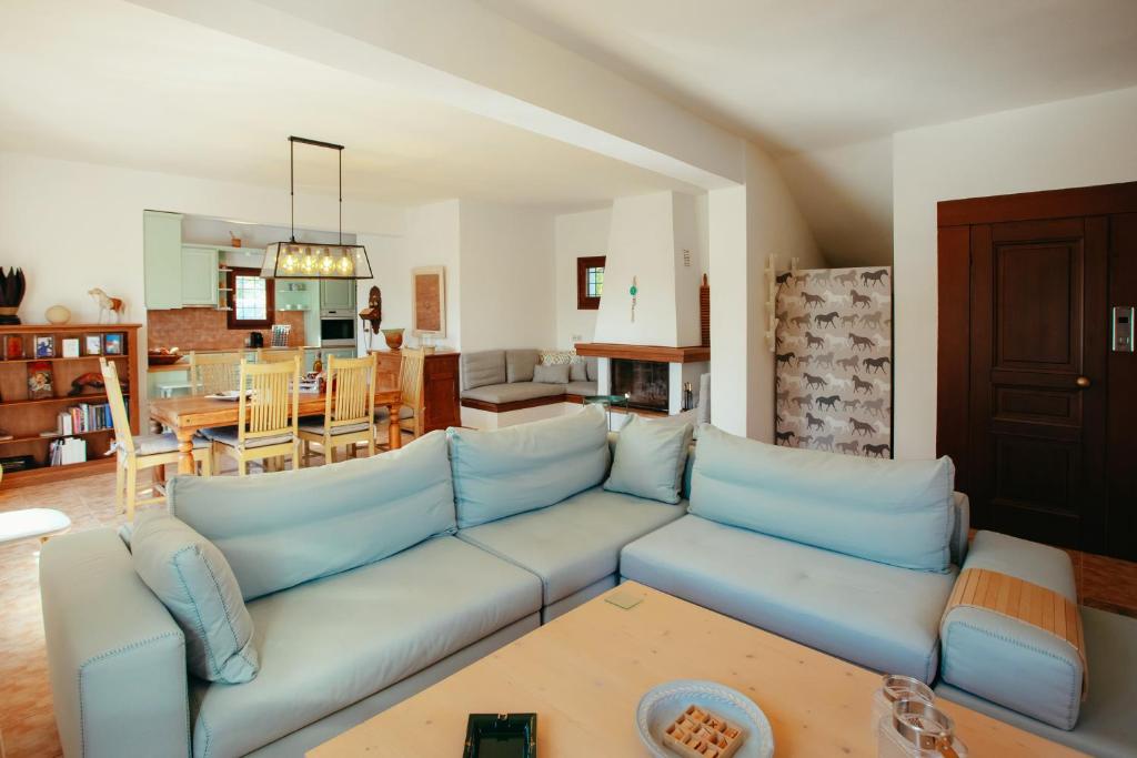 salon z niebieską kanapą i kuchnią w obiekcie Βίλλα Φανούλα Villa Fanoula w mieście Chorto