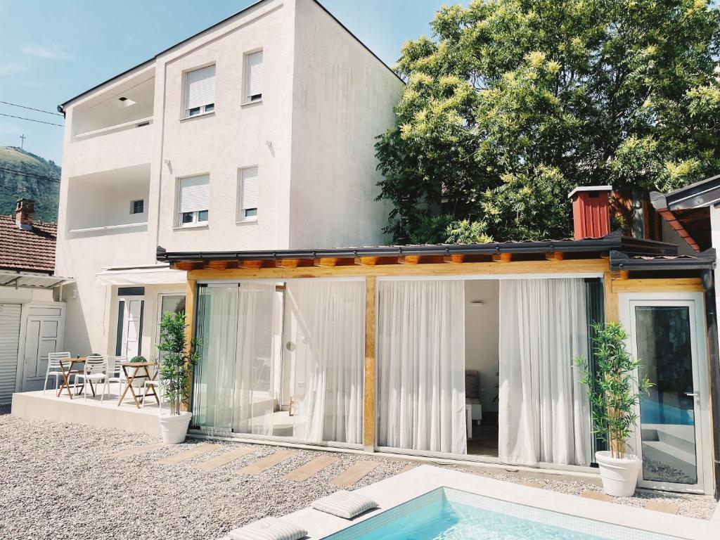 una casa con piscina frente a ella en City Apartment One en Mostar