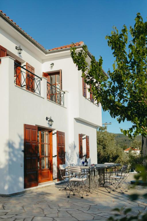 biały budynek ze stołem i krzesłami w obiekcie Βίλλα Φανούλα Villa Fanoula w mieście Chorto