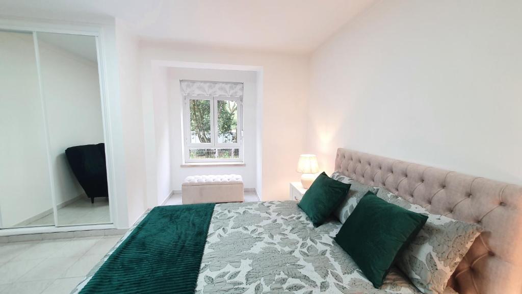 ein Schlafzimmer mit einem großen Bett mit grünen Kissen in der Unterkunft Caldas da Rainha's Green & White in Caldas da Rainha