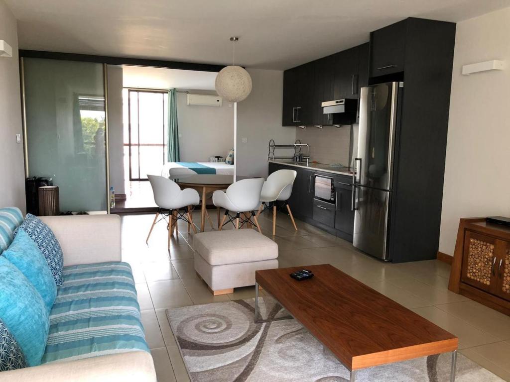 蒙舒瓦西的住宿－Appartement cozy et élégant à 5 minutes des plages，厨房以及带沙发和桌子的客厅。