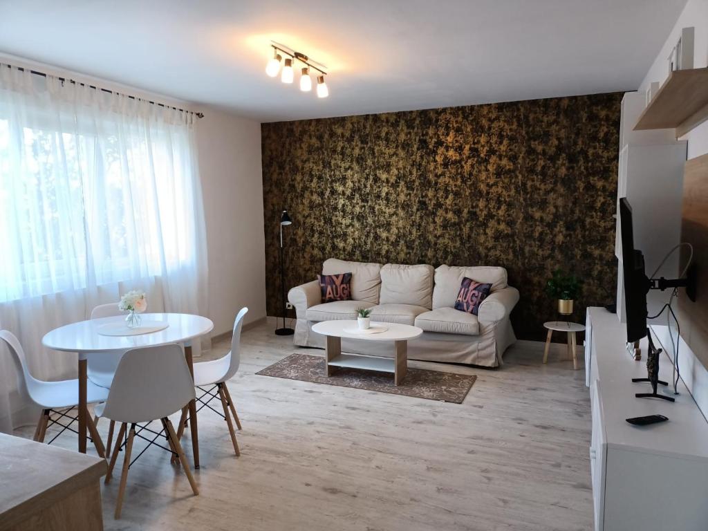 een woonkamer met een bank en een tafel bij Cozy Apartments in Timişoara