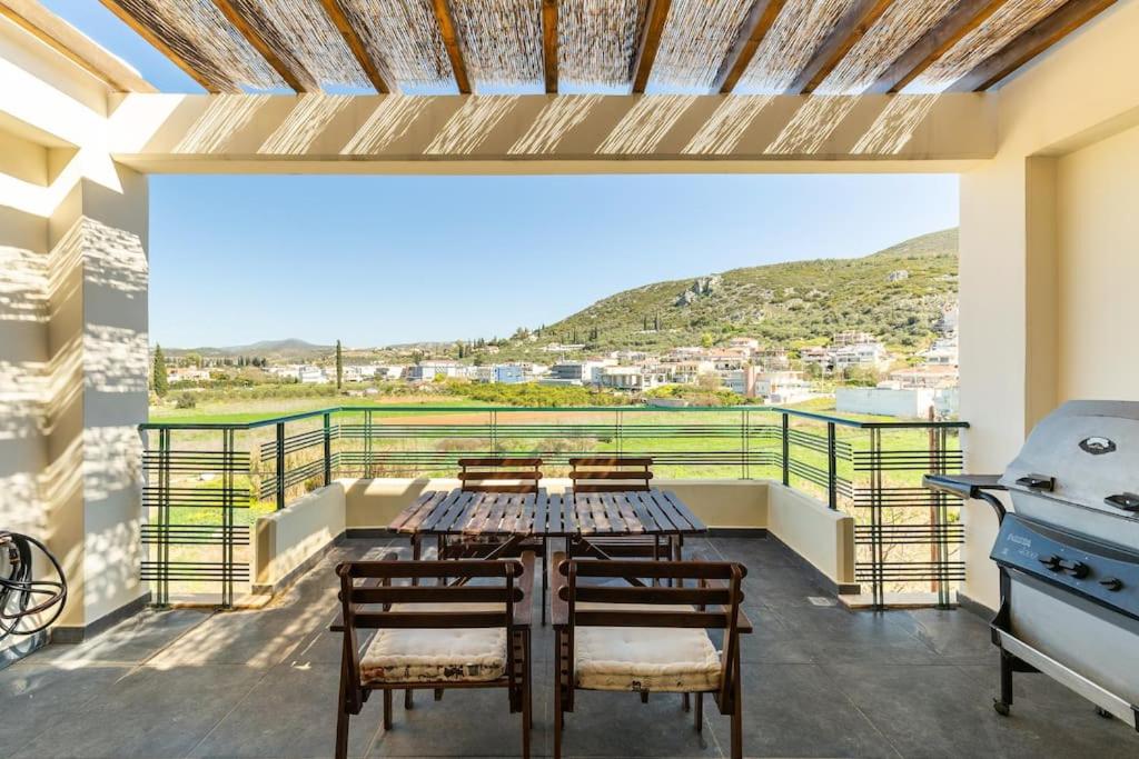 een balkon met een tafel en stoelen en een grill bij MYRTO Living in luxury and enjoying the view in Ária
