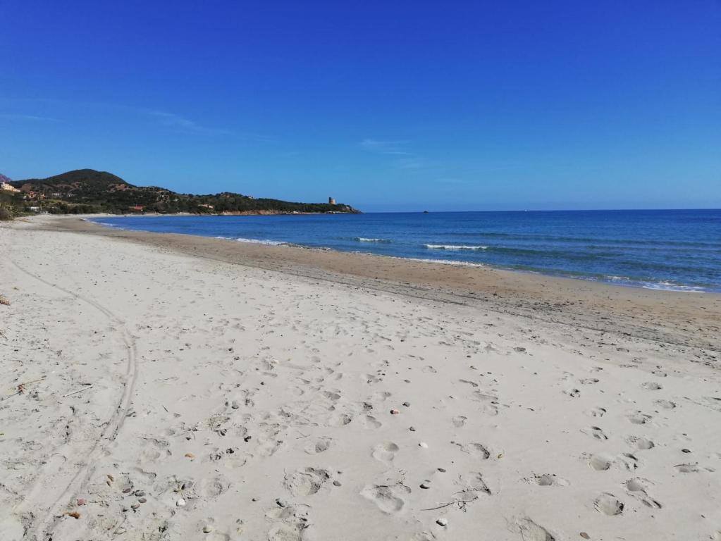 una playa con huellas en la arena y el océano en Villa Julia, en Tertenìa