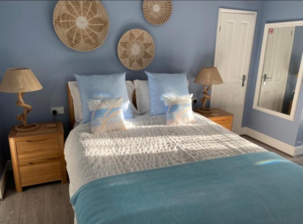 a bedroom with a large bed with blue walls at Sea Breeze Apartment Skegness in Skegness