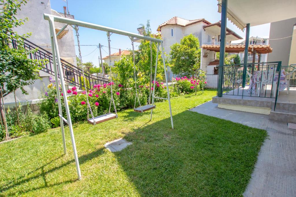 a garden with swings in the yard of a house at Lola Rooms in Nea Vrasna