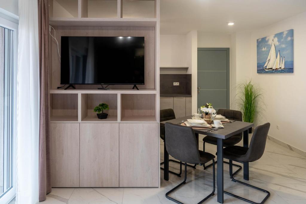 Televízia a/alebo spoločenská miestnosť v ubytovaní Apartmani Dalmacija Drage
