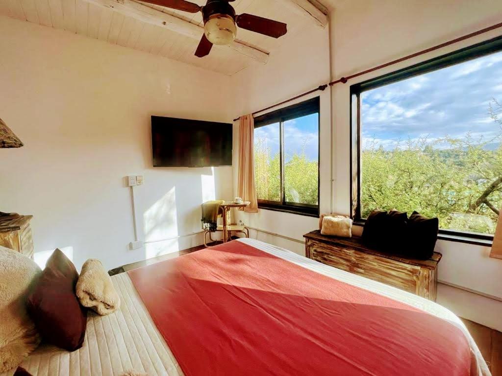 a bedroom with a large bed and a large window at LOFT LA CAYETANA, Grupo Cabaña La Triada in Río Ceballos