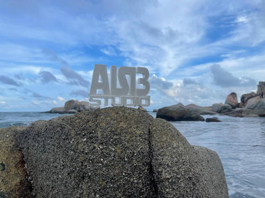 Un cartello che si posa su una roccia nell'oceano di AISI3 Studio Seaview at Tanjung Lumpur a Kuantan