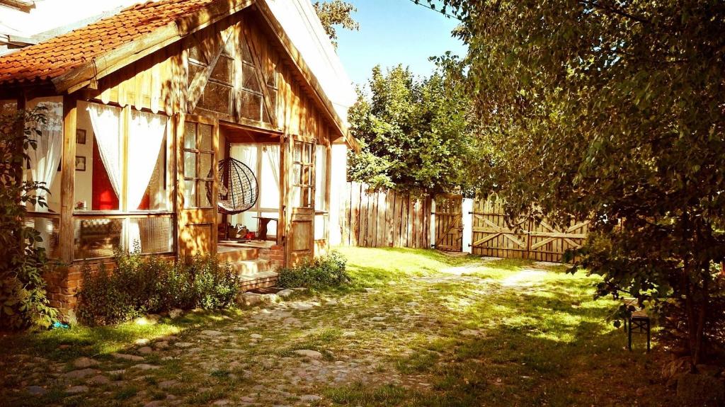 een oud huis met een grasveld ernaast bij Mazurskie Klimaty - niezależny, ogrodzony dom in Wydminy