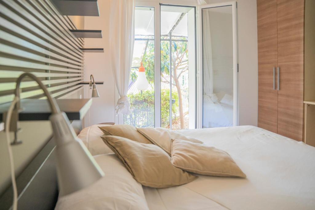 ein Schlafzimmer mit einem Bett mit Kissen und einem Fenster in der Unterkunft MIMOSA - Villa Luisa: Pace, Relax a 2 passi dal mare in Casarza Ligure