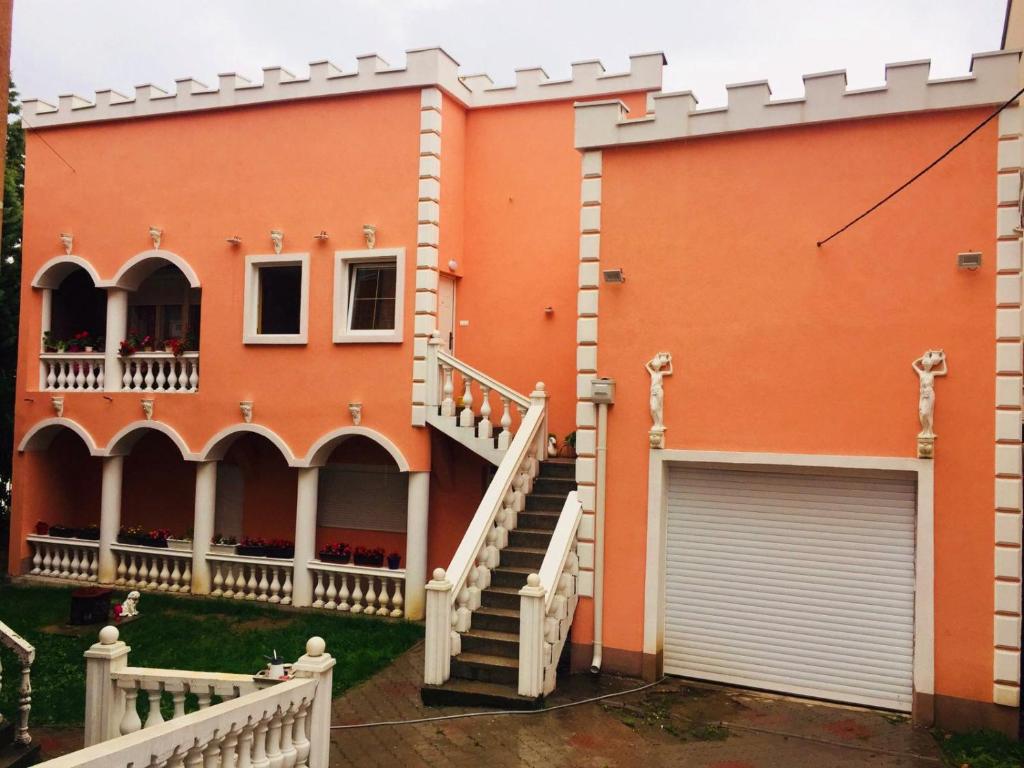 an orange house with a staircase and a garage at Apartmani "M" br3 in Topola