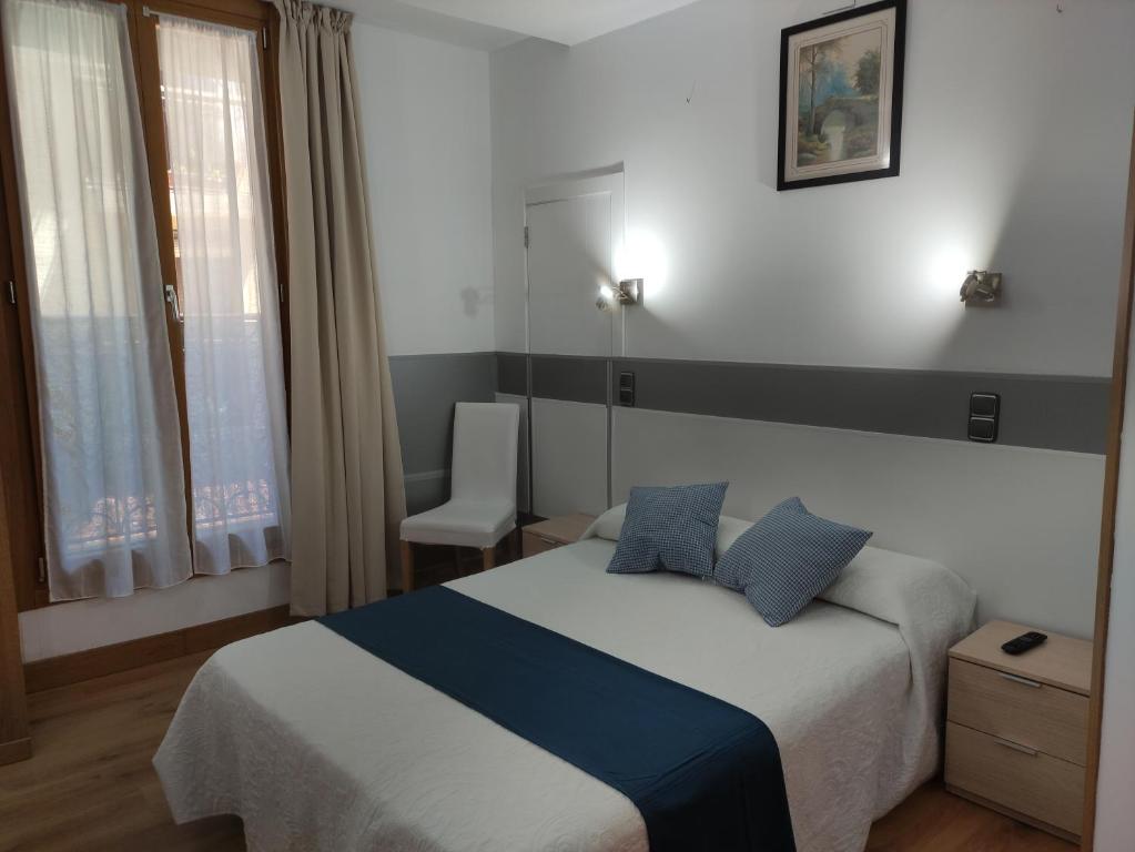 1 dormitorio con 1 cama, 1 silla y 1 ventana en AlojaDonosti City Center, en San Sebastián