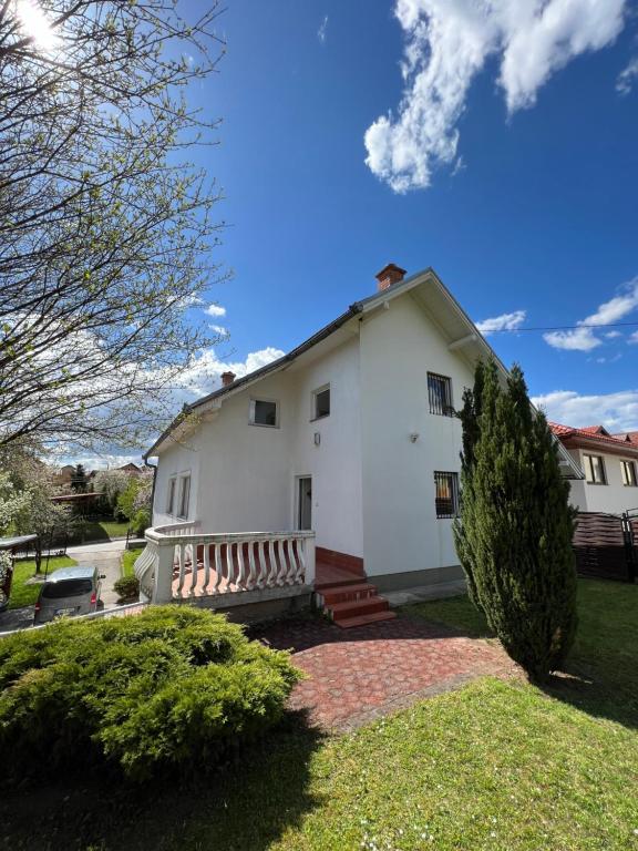 a white house with a porch and a yard at Villa ''M&A'' in Sarajevo