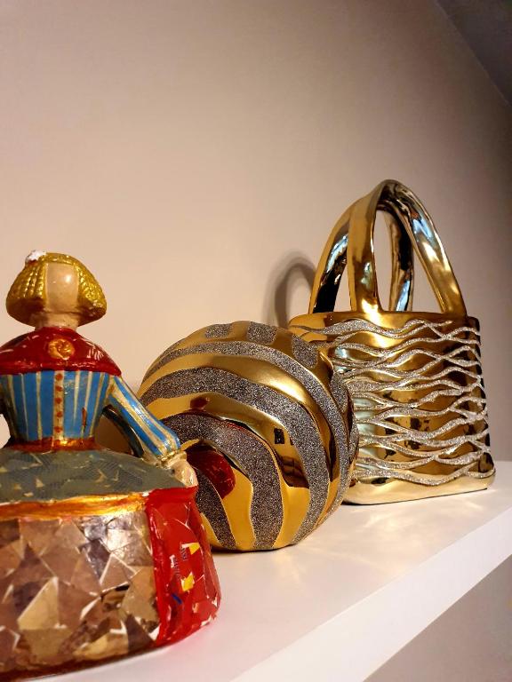 un gruppo di oggetti d'oro e d'argento su uno scaffale di Apartamento Luz a Valencia
