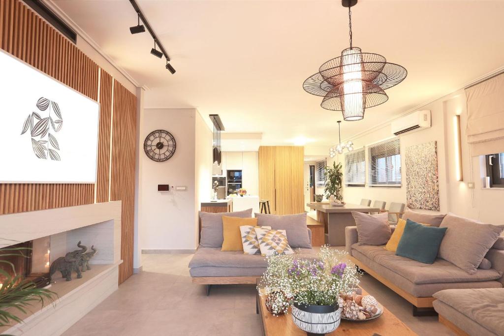 Agave, Luxury Apt in Faliro في أثينا: غرفة معيشة مع أريكة ومدفأة
