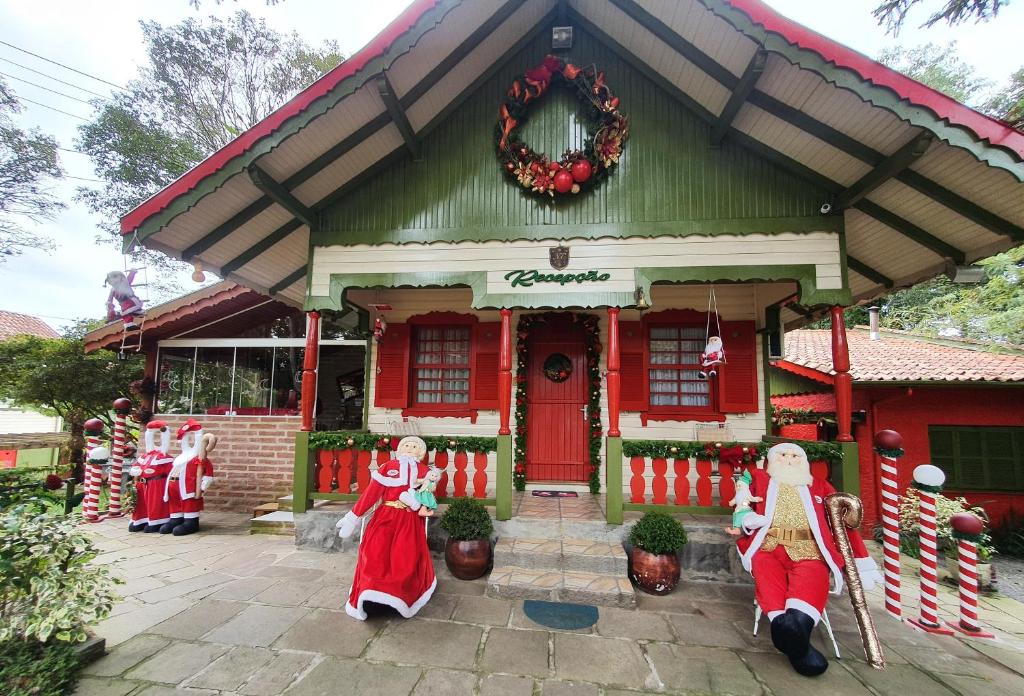 una casa decorada para Navidad con santas delante de ella en Pousada Natal Encantado, en Gramado
