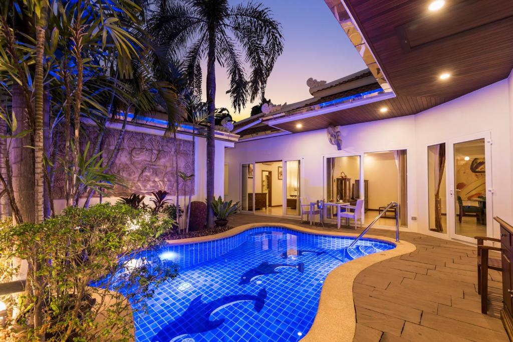 Village Austria Luxury Pool Villas في جنوب باتايا: مسبح في الحديقة الخلفية لبيت به منزل