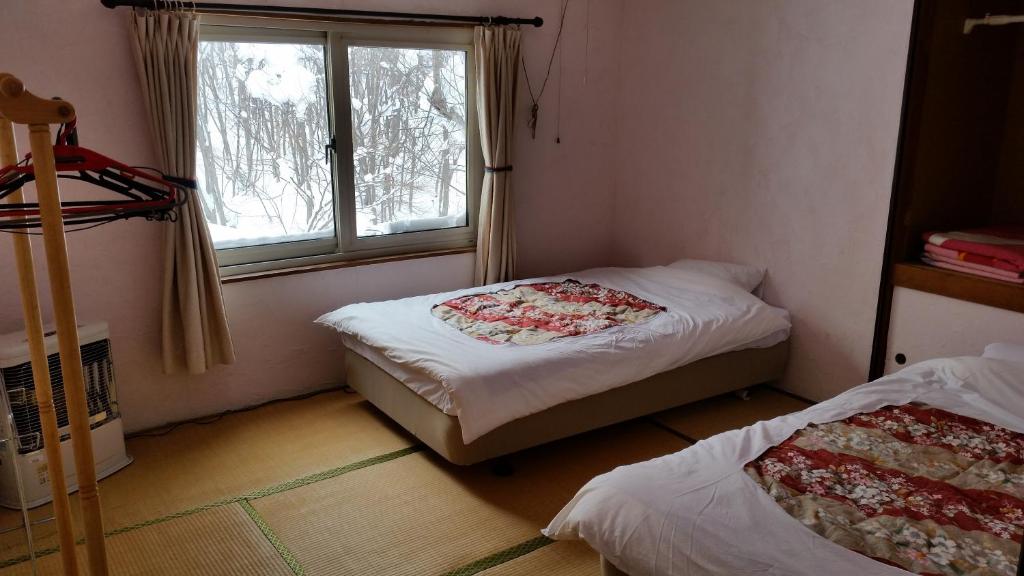 Postel nebo postele na pokoji v ubytování Niseko Higashiyama Guest House