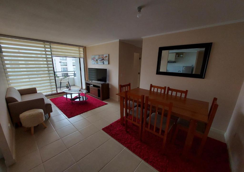 cómodo y bello departamento en la serena في لا سيرينا: غرفة معيشة مع أريكة وطاولة في غرفة