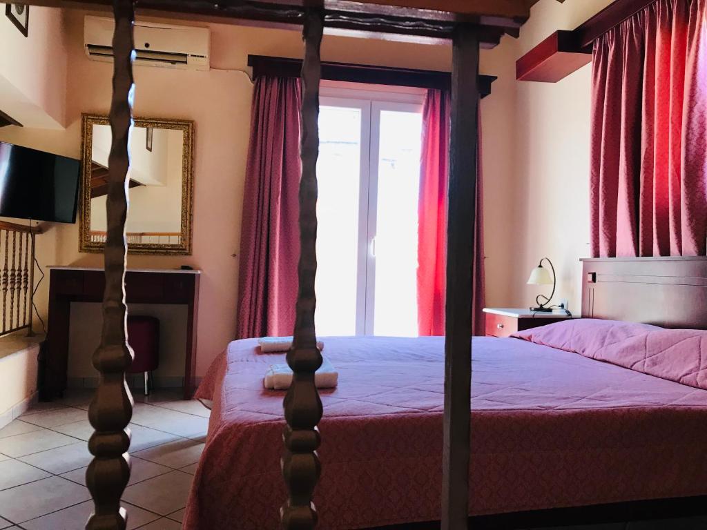 a bedroom with a four poster bed and a window at L'eremo Luxury Messonete in Roda