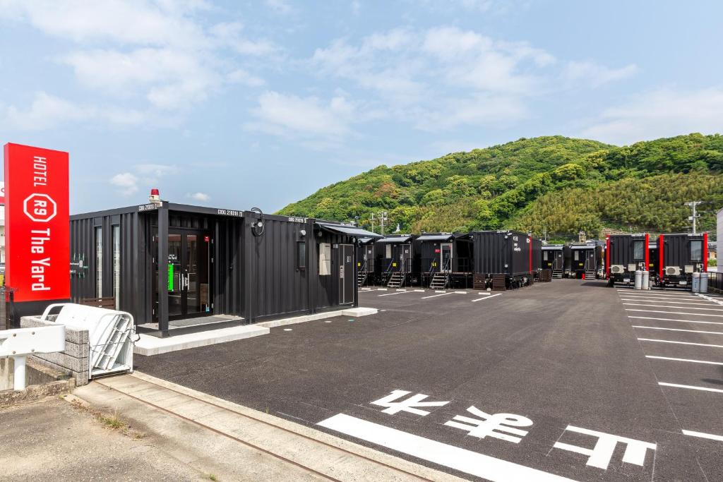 a parking lot with a bunch of black trailers at HOTEL R9 The Yard Kohoku in Saga