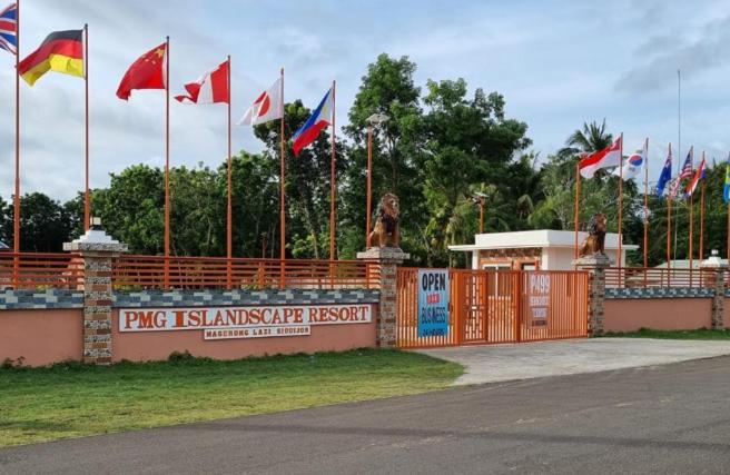 un montón de banderas están volando delante de una valla en PMG Islandscape Resort, en Siquijor